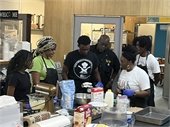 Teens participating in the A Seat At The Table program learning kitchen skills