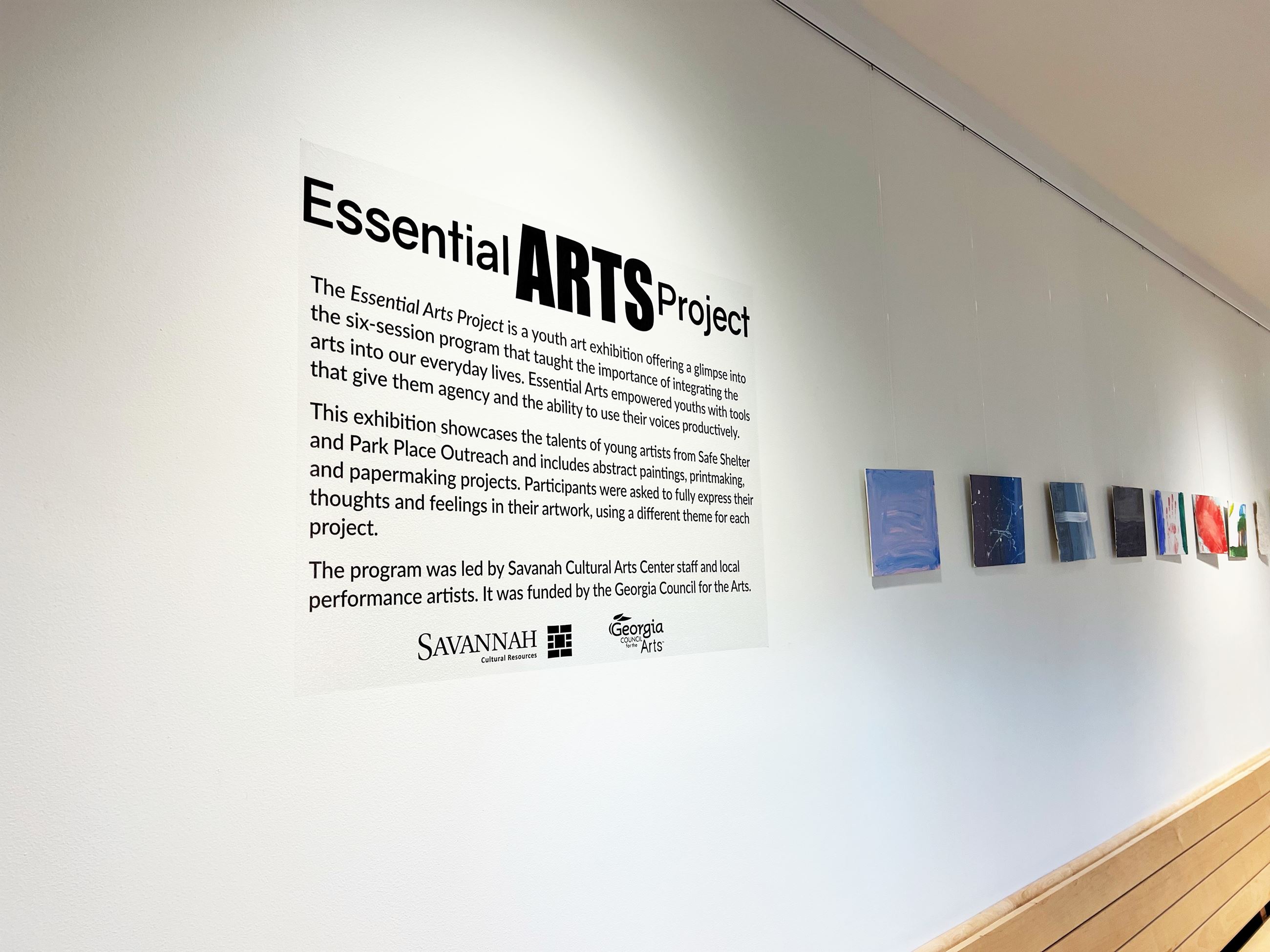 Artwork handing on wall with Essential Arts title in vinyl letters